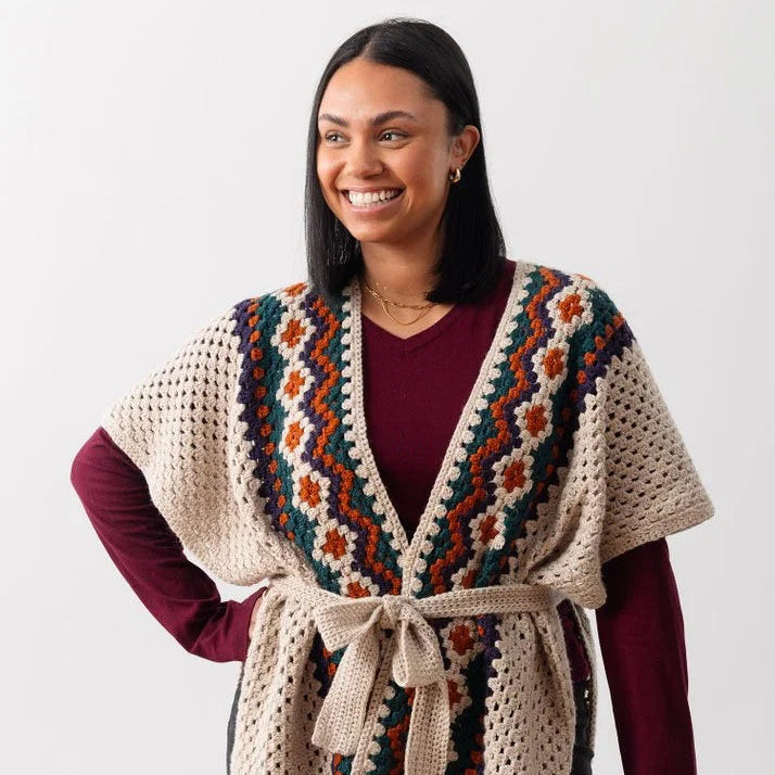 Smiling woman wearing a patterned granny stripe ruana