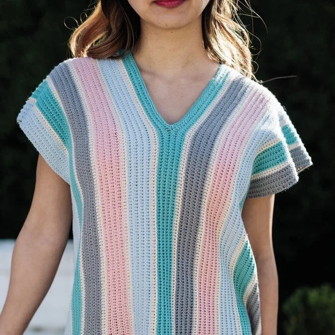 Woman wearing a pastel striped v-neck short sleeve crocheted top